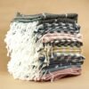 A neatly stacked pile of colorful striped Turkish towels with fringe details.