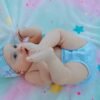 pexels-photo-8773748-8773748 Cute baby in a blue outfit playing on a colorful star-patterned blanket.